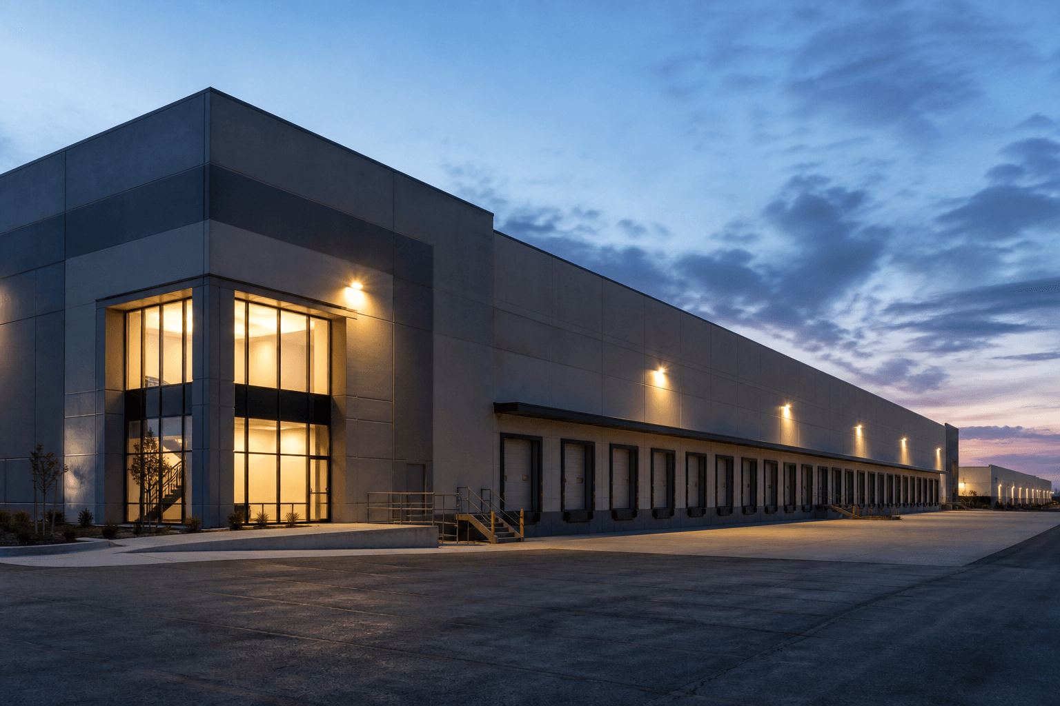 An industrial warehouse and loading dock at dusk